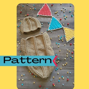 Puede incluir: Un conjunto de saco de dormir y gorro para bebé tejido a crochet en color beige. El conjunto está colocado sobre una superficie de madera con confeti de estrellas de colores esparcidos a su alrededor. El saco de dormir tiene una textura acanalada y el gorro tiene un diseño sencillo.