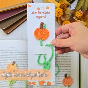 Puede incluir: Un marcapáginas de ganchillo con forma de calabaza naranja con tallo y hoja verdes, y tallo marrón. El marcapáginas tiene el texto "Pick of the Patch for cozy readel". También es visible el texto "digital crochet pattern".