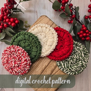 May include: A collection of handmade crochet coasters in various colors, including red, green, and cream. The coasters are arranged on a wooden board, with text that reads "digital crochet pattern". Decorative red berries and greenery surround the coasters.
