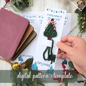 Pode incluir: Um marcador de livro de árvore de Natal verde de crochê feito à mão com um laço vermelho e branco, preso a um cartão branco. O cartão tem o texto "A merry marker to save your spot!" e "Happy Reading". As palavras "digital pattern + template" também são visíveis.