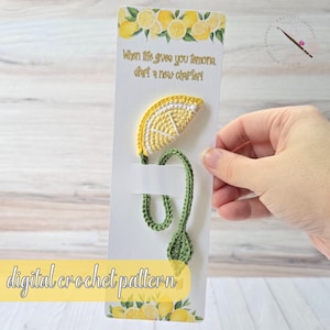 Könnte beinhalten: Handgefertigter Häkel-Lesezeichen mit einem gelben Zitronenscheiben-Design und einem grünen Stiel und Blatt. Der Lesezeichentext lautet: "When life gives you lemons, start a new chapter!" und "digital crochet pattern".