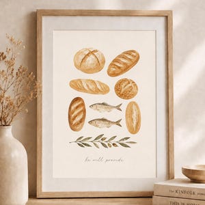 May include: A framed wall art print featuring watercolor illustrations of various loaves of bread, two fish, and an olive branch. The text "he will provide" is printed in a delicate script font at the bottom center of the off-white paper background.