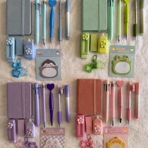 May include: A collection of stationery sets organized by color, including four notebooks, multi-color pens, heart-topped pens, flower-adorned utility knives, erasers, star-shaped keychains, and Animal Paradise sticky notes in blue, green, purple, and pink.