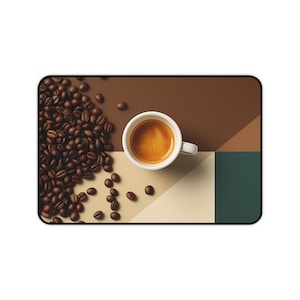 May include: A rectangular desk mat featuring a top-down view of a white espresso cup filled with coffee, positioned next to a large cluster of roasted brown coffee beans. The background is divided into geometric sections of brown, beige, and dark green.
