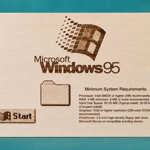 May include: A rectangular light-coloured wooden plaque laser-engraved with the Microsoft Windows 95 logo, a folder icon, a Start button, and the text Minimum System Requirements listing processor, RAM, hard disk space, graphics, and peripheral specifications.