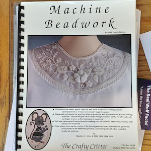 May include: A spiral-bound book titled "Machine Beadwork" with a detailed embroidered collar on the cover. The cover features a mouse illustration and text about beadwork techniques and projects. The book is by Marilyn C. Allen.