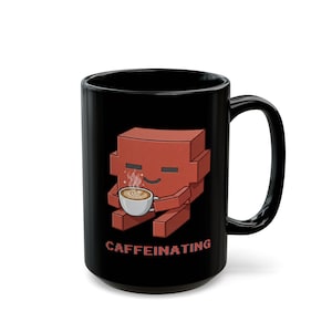 May include: A black ceramic mug featuring a pixelated red block-shaped character holding a white coffee cup with steam rising from it. Below the character, the word CAFFEINATING is printed in a pixelated red font, matching the character's color.