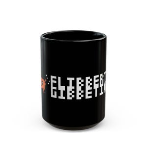 Peut inclure: Un mug en céramique noire orné d'un personnage carré orange pixélisé sur le côté gauche et d'un texte blanc pixélisé indiquant ELITEBEET GIEBEETIN sur le côté droit. Le mug présente une forme cylindrique avec une finition lisse et brillante.