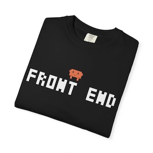 May include: A black t-shirt featuring the white pixelated text FRONT END with a small orange pixelated creature graphic positioned between the two words. The shirt has a white interior neck label with black text visible at the collar area.