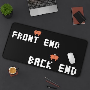 May include: A rectangular black desk mat featuring white pixelated text that reads FRONT END and BACK END, with two small orange pixelated creature graphics positioned above each line of text, providing a surface for a computer mouse.