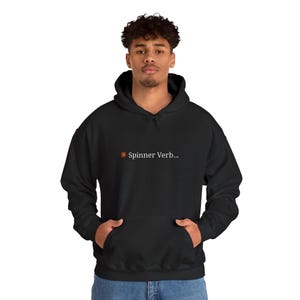 May include: A black hooded sweatshirt featuring a front kangaroo pocket and a small graphic on the chest. The graphic consists of an orange sun icon followed by the white text "Spinner Verb..." printed in a clean, sans-serif font.