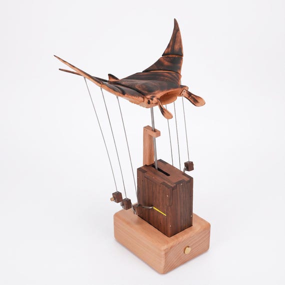A hand-carved wooden manta ray that balances and sways kinetically on your desk — part sculpture, part mesmerizing fidget object.