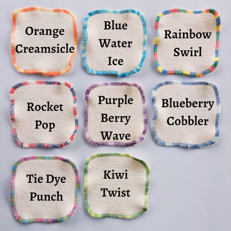 May include: Nine fabric squares with colorful borders and text. The squares are labeled with different flavor names, such as "Orange Creamsicle", "Blue Water Ice", "Rainbow Swirl", "Rocket Pop", "Purple Berry Wave", "Blueberry Cobbler", "Tie Dye Punch", "Kiwi Twist".