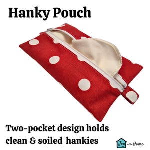 May include: Red fabric pouch with white polka dots and a zipper closure. The pouch has a small handle and is designed to hold two separate compartments for clean and soiled handkerchiefs. The text "Hanky Pouch" and "Two-pocket design holds clean & soiled hankies" is visible on the image. The logo "Joy in the Home" is also visible.