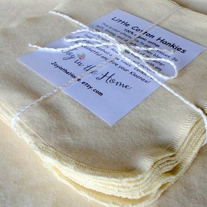 May include: A bundle of pale yellow cotton hankies tied with white string. A white label with black text reads "Little Cotton Hankies" and includes care instructions. The Etsy shop name "Joy in the Home" is also visible.