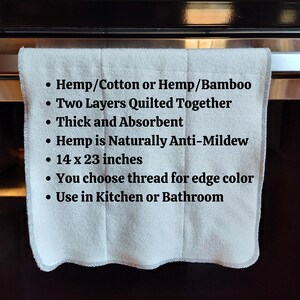 May include: A white kitchen towel made from hemp and cotton or hemp and bamboo. It is quilted with two layers and is absorbent. The towel is 14 by 23 inches and has a choice of thread colours for the edge. The text on the towel reads: "Hemp/Cotton or Hemp/Bamboo, Two Layers Quilted Together, Thick and Absorbent, Hemp is Naturally Anti-Mildew, 14 x 23 inches, You choose thread for edge colour, Use in Kitchen or Bathroom."