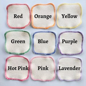 May include: Nine cotton rounds with coloured stitching, each labelled with a colour: Red, Orange, Yellow, Green, Blue, Purple, Hot Pink, Pink, and Lavender.