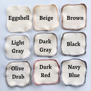 Peut inclure: Neuf &eacute;chantillons de tissu de diff&eacute;rentes couleurs, notamment coquille d'&oelig;uf, beige, marron, gris clair, gris fonc&eacute;, noir, olive fonc&eacute;, rouge fonc&eacute; et bleu marine. Chaque &eacute;chantillon est un carr&eacute; avec une bordure contrast&eacute;e autour des bords.