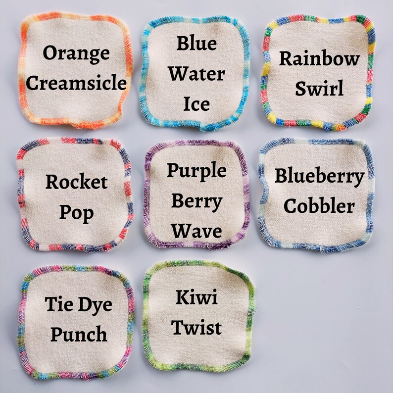 May include: Nine fabric squares with colourful borders and text. The squares are labelled with different flavour names, such as "Orange Creamsicle", "Blue Water Ice", "Rainbow Swirl", "Rocket Pop", "Purple Berry Wave", "Blueberry Cobbler", "Tie Dye Punch", "Kiwi Twist".