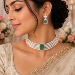 Puede incluir: Un collar tipo gargantilla de varias hileras de perlas con una piedra preciosa rectangular verde central en un marco plateado con piedras claras, junto con pendientes colgantes de piedra verde rectangular a juego.