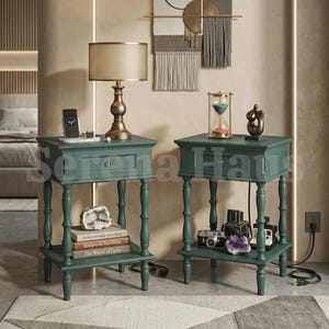 May include: Two dark green wooden nightstands, each featuring a single drawer with a round knob, four turned legs, and a lower shelf. The left nightstand holds a lamp, a phone stand, and books. The right nightstand holds an hourglass and decor.