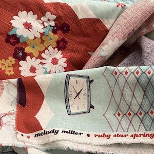 Op de afbeelding: Stof met een silhouet van een persoon in donkerrood, een bloemenpatroon en een retro wekker op een lichtblauwe achtergrond. De zelfkant toont de tekst melody miller ruby star spring 2012 met kleine rode sterpictogrammen.