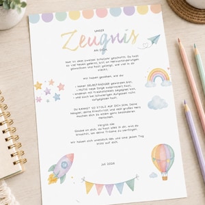 Puede incluir: Un certificado de papel blanco titulado Unser Zeugnis an Dich con ilustraciones en acuarela de tonos pastel que incluyen un cohete, un globo aerostático, un arcoíris y estrellas. El texto está en alemán y felicita a un estudiante, fechado en julio de 2026.