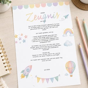 Puede incluir: Una hoja de papel rectangular blanca con ilustraciones en tonos pastel que incluyen un cohete, un globo aerostático, un arcoíris, estrellas y banderines. El texto dice Unser Zeugnis an dich, seguido de un texto en alemán, fechado en Juli 2026.