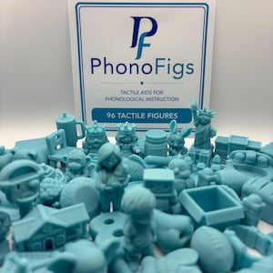 May include: A collection of light blue tactile figures for phonological instruction, arranged in front of a white sign with the text PhonoFigs TACTILE AIDS FOR PHONOLOGICAL INSTRUCTION 96 TACTILE FIGURES. The figures include various shapes.