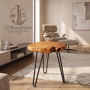 May include: A side table with a natural live-edge wood slab top featuring a prominent knot and three slender black metal hairpin legs. The table is positioned in a room with a logo on the wall that reads JLWoodHaven Handcrafted Wooden Furniture.