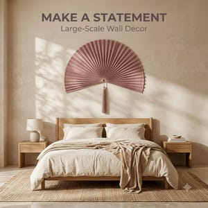 Before and after bedroom wall transformation showing a plain wall changed with a large dusty rose bamboo wall fan above the bed.