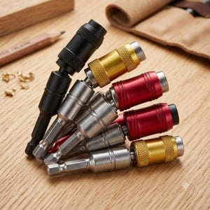May include: A collection of six metal drill bit extension holders with hexagonal shanks. The holders feature various finishes including matte black, metallic silver, brushed gold, and vibrant red, with knurled grip sections on the cylindrical bodies.