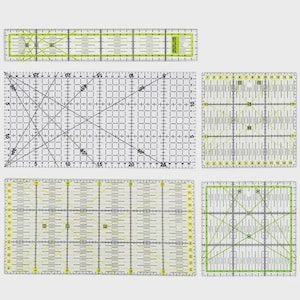 Puede incluir: Un conjunto de cinco reglas de acolchado de acrílico transparente con líneas de cuadrícula negras, marcas amarillas y guías de ángulo diagonales. El set incluye varias formas rectangulares y cuadradas con medidas métricas impresas.