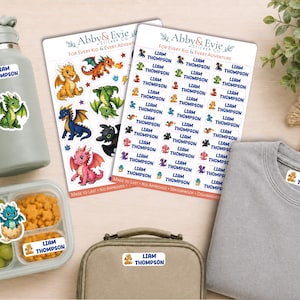 May include: Two sheets of personalized name stickers featuring the text Liam Thompson and various colorful dragon illustrations, alongside a gray water bottle, a food container with grapes and crackers, a lunch bag, and a gray shirt with labels.