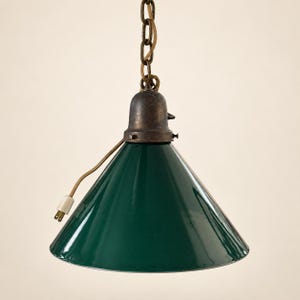 May include: A dark green conical pendant lamp with a glossy finish, featuring a dark bronze-toned metal socket and a matching chain suspension. A thin electrical cord with a white two-pin plug extends from the side of the metal fixture.