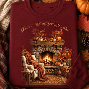 Camiseta de manga larga Bella + Canvas con escena acogedora de chimenea / Ilustración de sala de estar otoñal