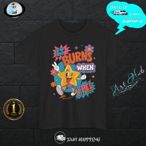 Può includere: Una t-shirt nera a maniche corte con la grafica di una stella gialla con un volto, che indossa pantaloncini viola e scarpe da ginnastica rosse. Il testo recita IT BURNS WHEN I PEE, circondato da fiori colorati, stelle e nuvolette da fumetto.