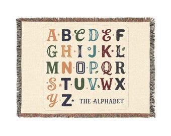Reversible vintage alphabet woven cotton throw with colorful fringes, textured design, and nostalgic classroom charm