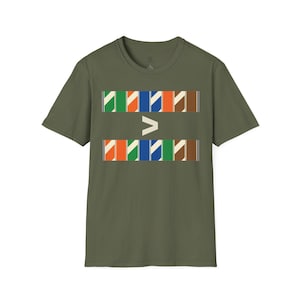 May include: An olive green short-sleeve t-shirt featuring a graphic print on the chest. The design consists of two horizontal rows of colourful rectangular blocks with diagonal stripes, separated by a large white greater-than symbol in the centre.