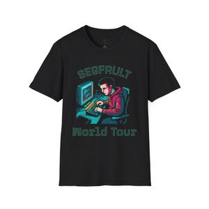 Peut inclure: Un t-shirt noir à manches courtes avec un graphisme en pixel art représentant une personne assise devant un ordinateur. Le texte "SEGFAULT" figure au-dessus et "World Tour" en dessous, tous deux dans une police verte de style rétro.