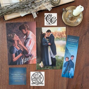 May include: A collection of printed paper items including two rectangular art prints featuring romantic couples, a tall bookmark titled A Courtship of Conspiracies, two square stickers with intricate black line art, and a small square quote card.