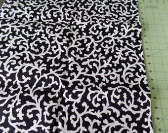 May include: Black and white fabric with a repeating pattern of stylized white branches on a black background.