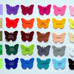 May include: A collection of felt butterfly cutouts arranged in a grid, each labeled with its corresponding color name including lilac, purple, plum, hot pink, pink, baby pink, tan, red, orange, dark yellow, yellow, light yellow, khaki green, dark brown, dark red, brown, peach, ivory, green, dark green, lime green, dark grey, grey, white, neon green, dark blue, blue, turquoise, light blue, and black.