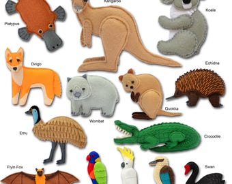 Puede incluir: Una colección de figuras de animales de fieltro que incluye un ornitorrinco marrón, un canguro beige, un koala gris, un dingo naranja, un wombat gris, un quokka beige, un equidna marrón, un emú beige, un cocodrilo verde, un zorro volador marrón, un lori colorido, una cacatúa blanca, un cucaburra y un cisne negro.