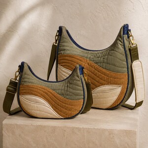 Può includere: Due borse a tracolla a mezzaluna con design trapuntato e pannelli ondulati in verde oliva, marrone chiaro e crema. Ogni borsa presenta profili blu scuro, finiture in metallo color ottone e una tracolla regolabile verde oliva imbottita.