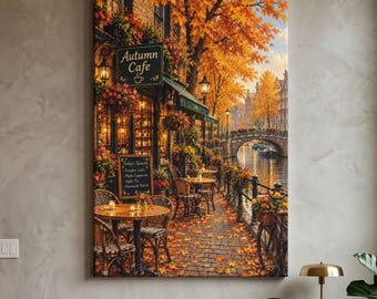 May include: A vertical wall art print depicting an Autumn Cafe with golden foliage, a brick patio, and outdoor seating. A sign reads Autumn Cafe, and a chalkboard menu lists items. A stone bridge spans a canal in the background under a clear sky.