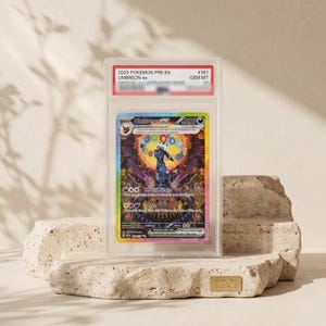 Op de afbeelding: Een gegradeerde 2025 Pokemon Umbreon ex ruilkaart in een doorzichtige plastic houder. De kaart toont een donker Umbreon-personage omringd door kleurrijke elementaire symbolen en ingewikkelde patronen. Het label bovenaan vermeldt 2025 POKEMON PRE EN #161 UMBREON ex GEM MT 10.