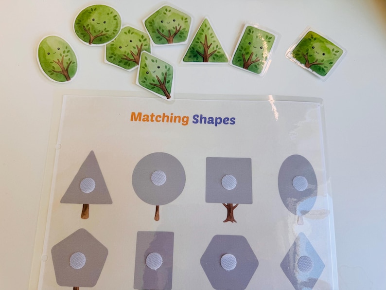 Laminated shape matching activity page laid out with various tree-shaped cutouts waiting to be matched by their geometric bases.