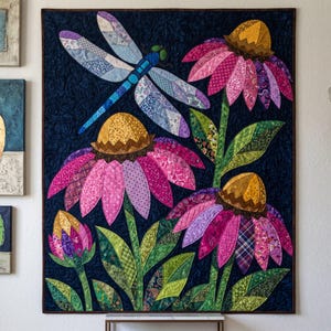 May include: A rectangular fabric wall hanging featuring a dark navy blue background with a quilted swirl pattern. The design displays three large coneflower blossoms in shades of pink and purple with yellow centres, green leaves, and a blue dragonfly.