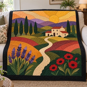 May include: A quilted throw blanket featuring a landscape scene with a winding path leading to a house, surrounded by purple lavender, red poppies, green hills, and tall cypress trees under a yellow sun and orange sky, finished with a black border.